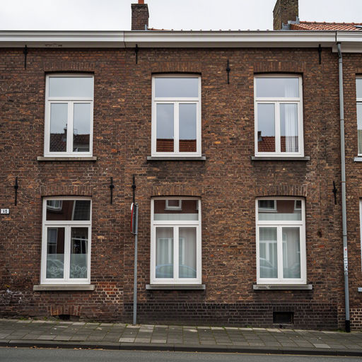 vooroorlogse rijtjeswoning in Buren met witte kunststof kozijnen aan de voorgevel